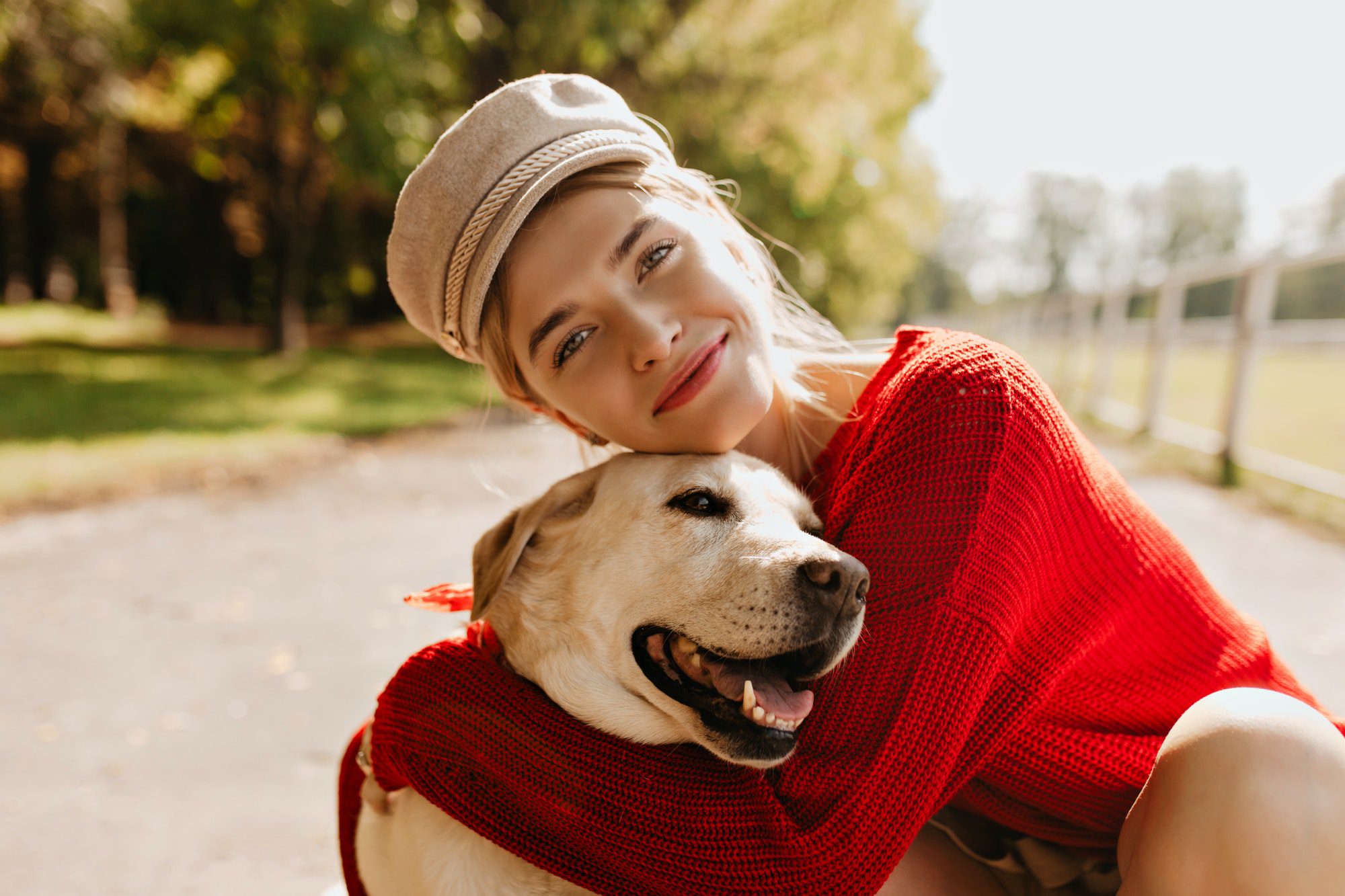 Charming girl and her dog having good time in the autumn park. Lovely blonde with beautiful dog pos